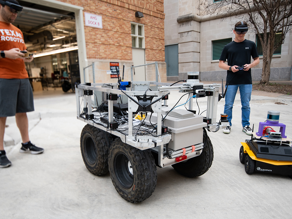 four-wheeled robots outside controlled by students with remotes
