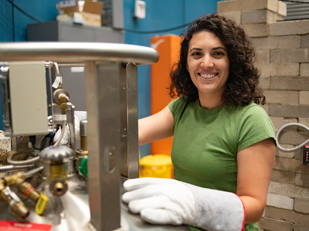 woman wearing heat proof gloves at machine